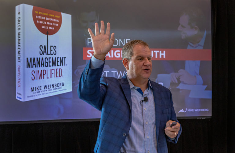 Mike standing in front of a slideshow featuring his book